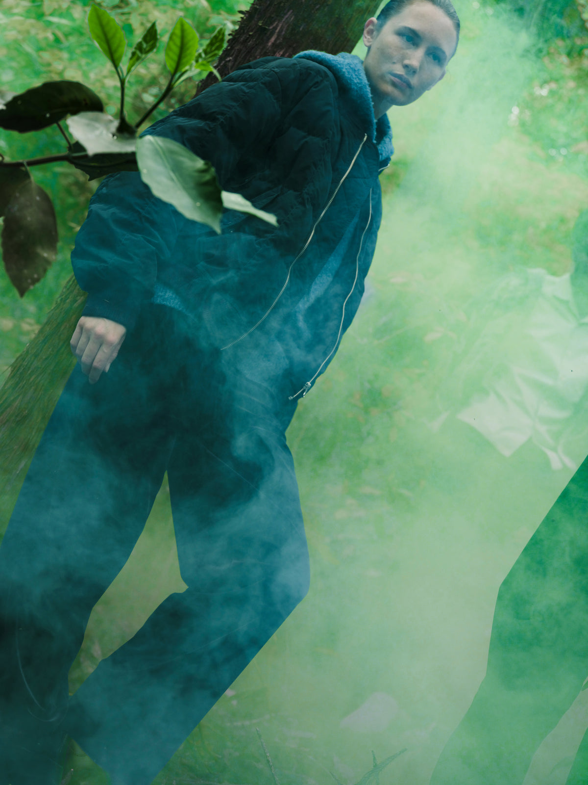 Little Yarmouth EP. 2. A figure in a dark quilted jacket amid green mist and woodland.