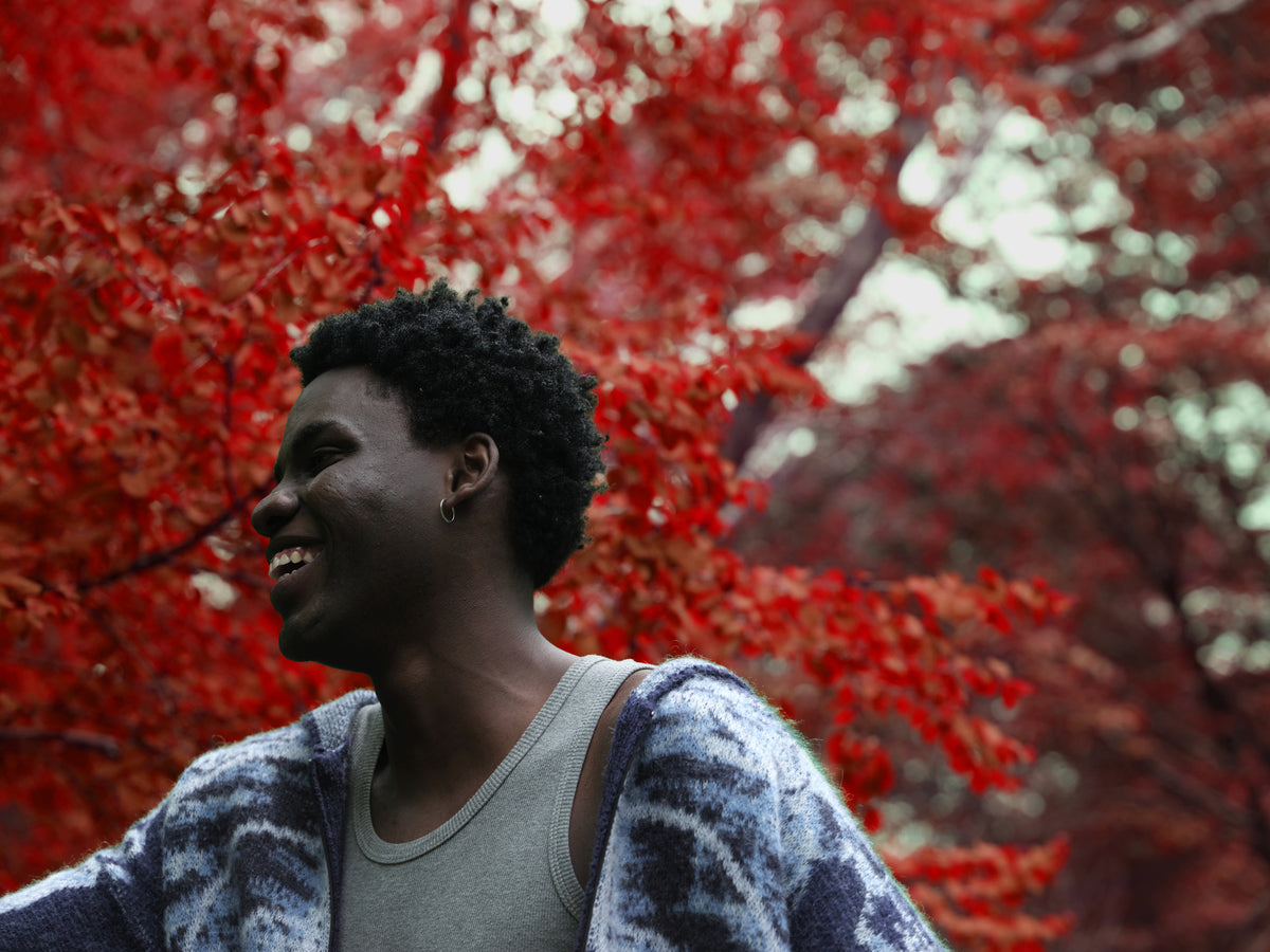 Little Yarmouth EP. 2. A portrait in a blue patterned knit under red leaves.
