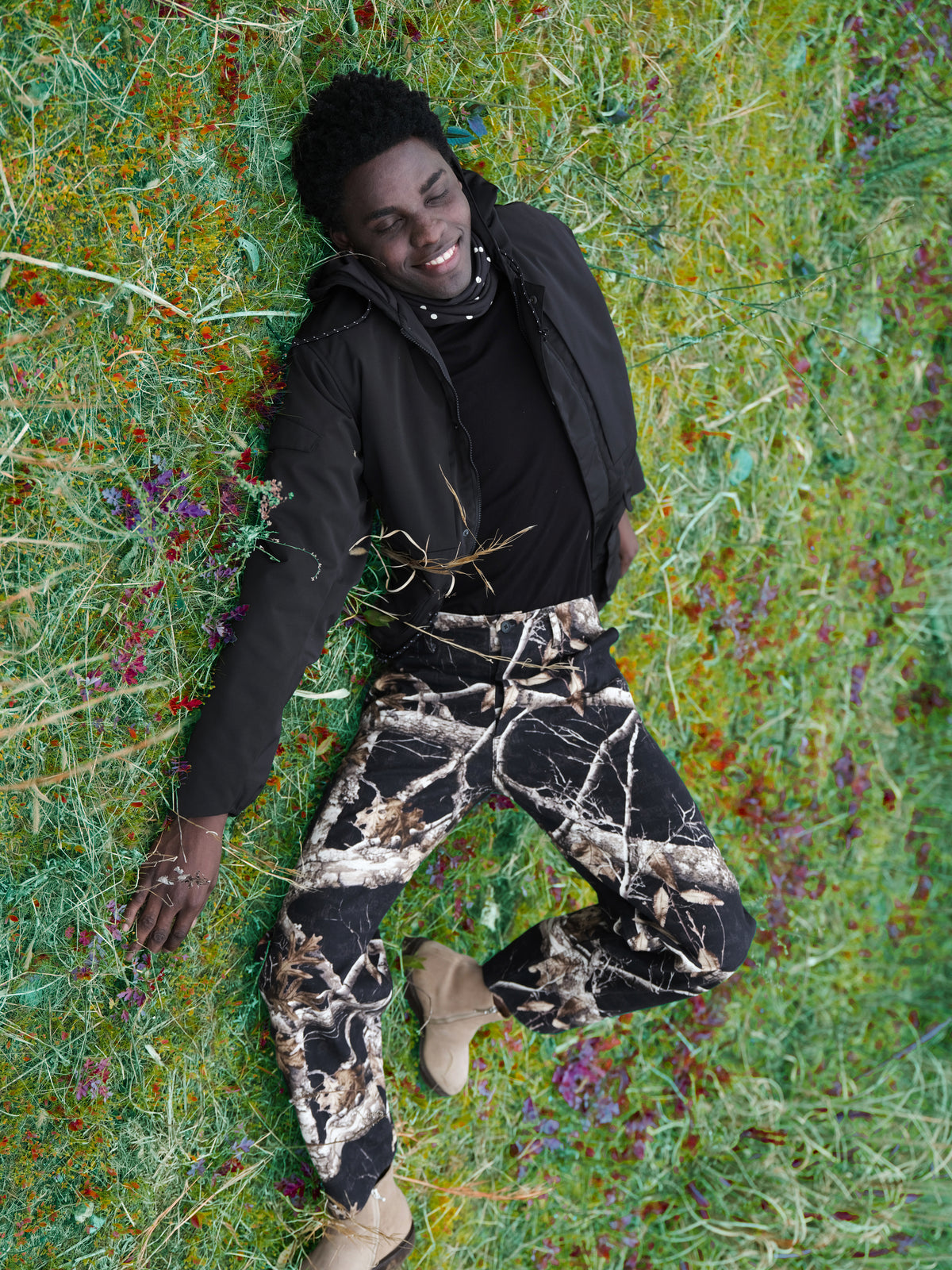 Little Yarmouth EP. 2. A black hooded top and patterned trousers amid green grass.