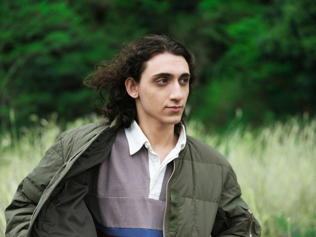 Little Yarmouth EP. 2. An olive jacket layered over a color-block rugby shirt.