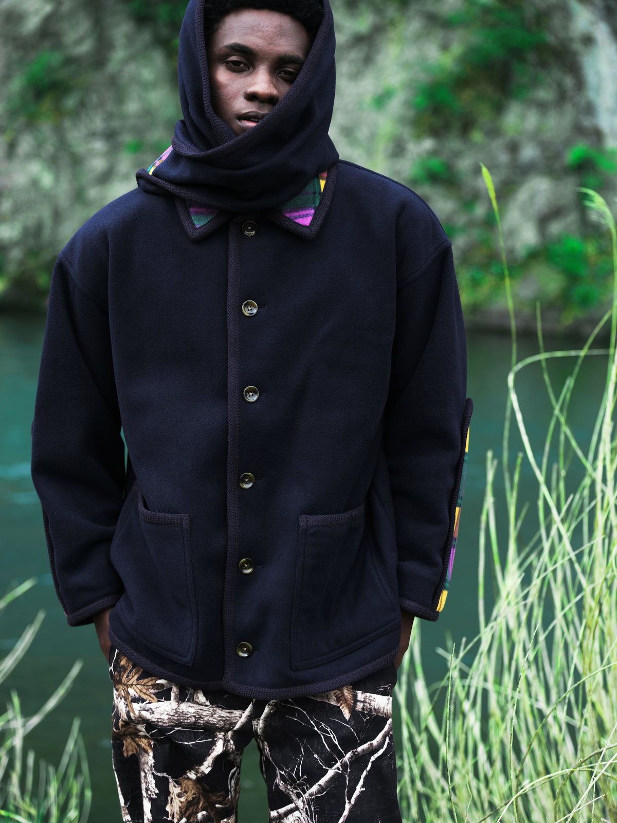 Little Yarmouth EP. 2. A dark jacket with a wrapped hood among green reeds.