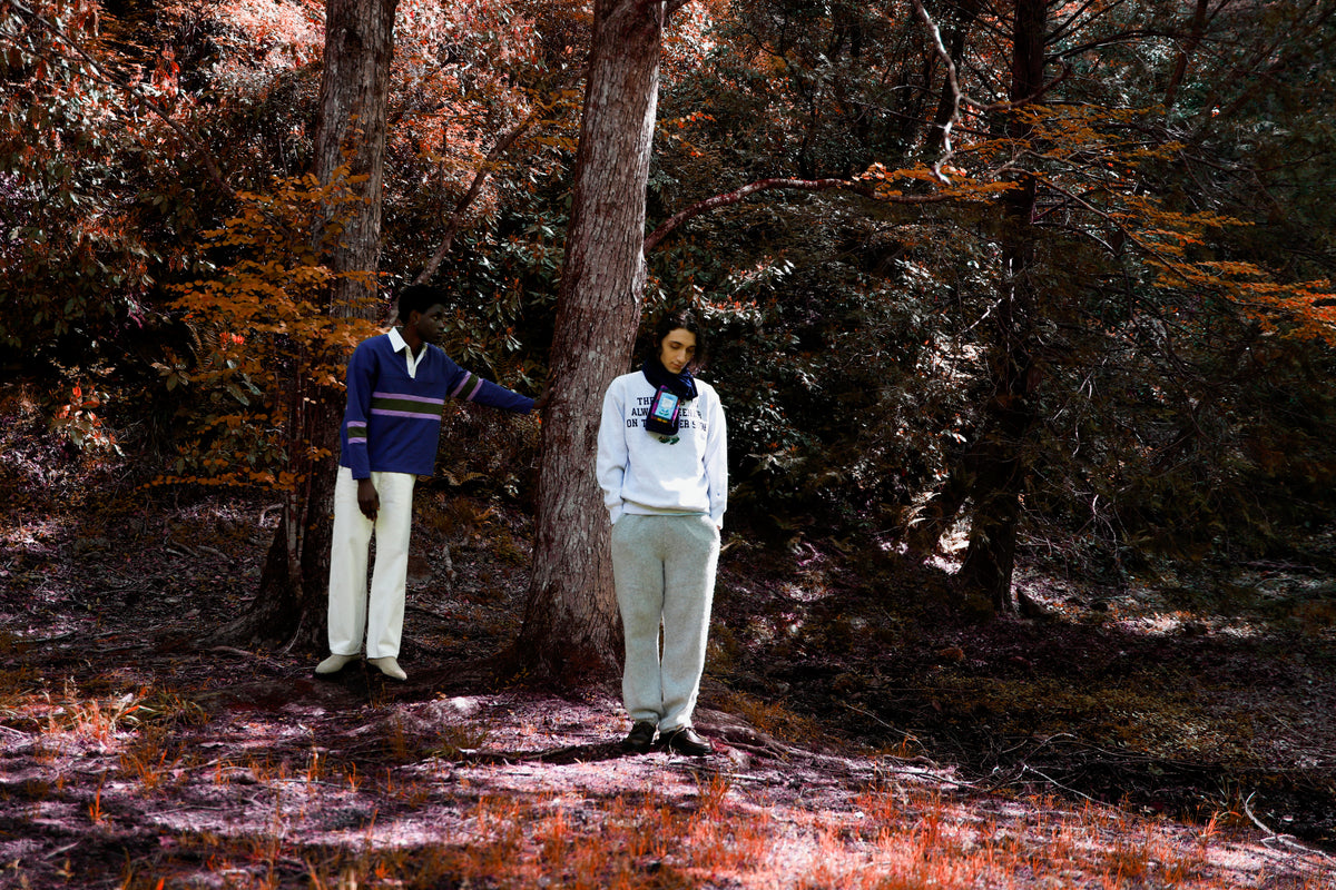 Little Yarmouth EP. 2. Two figures in purple and white layers in a sunlit autumn woodland.